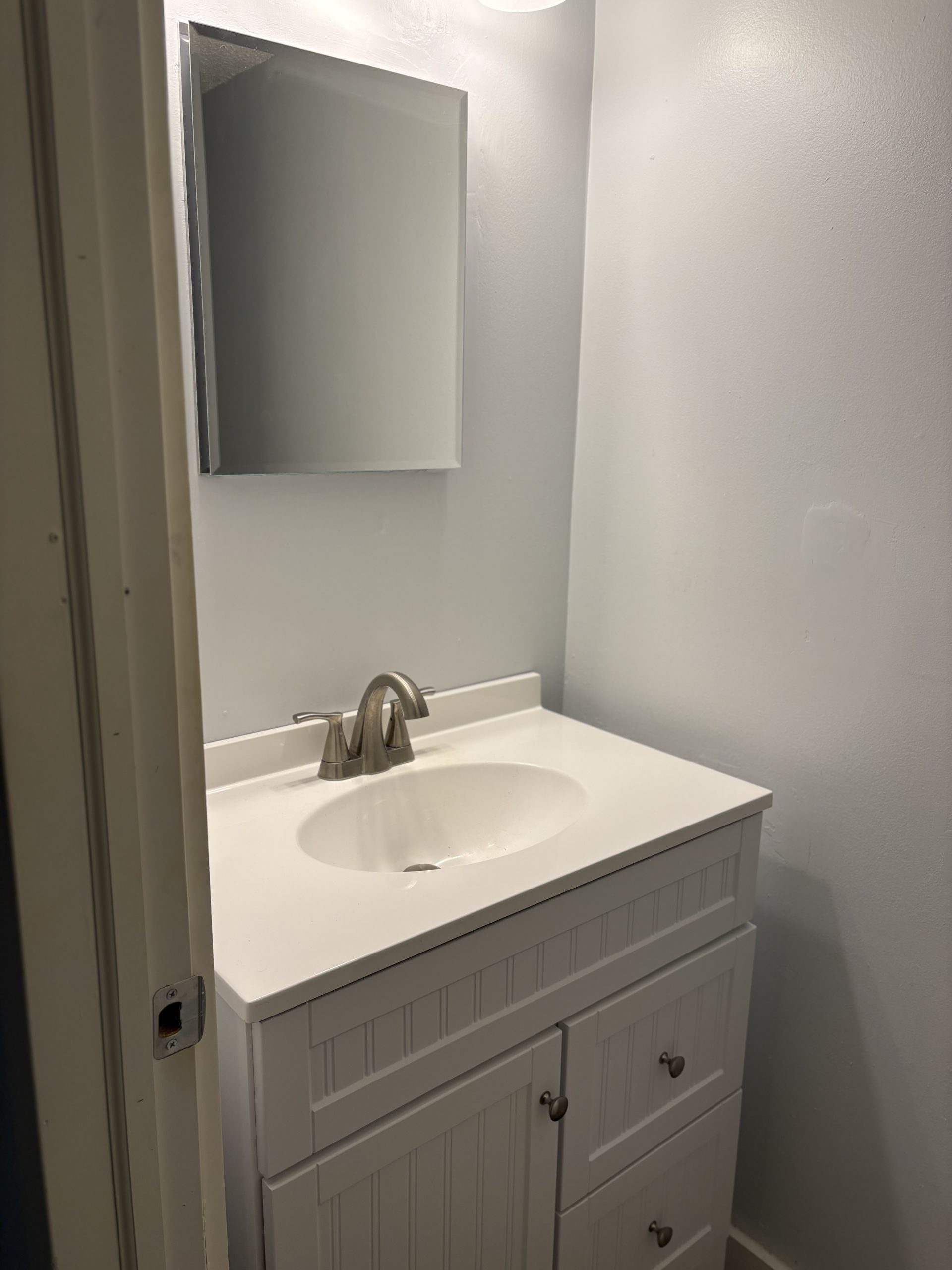Modern bathroom vanity with white sink and faucet.