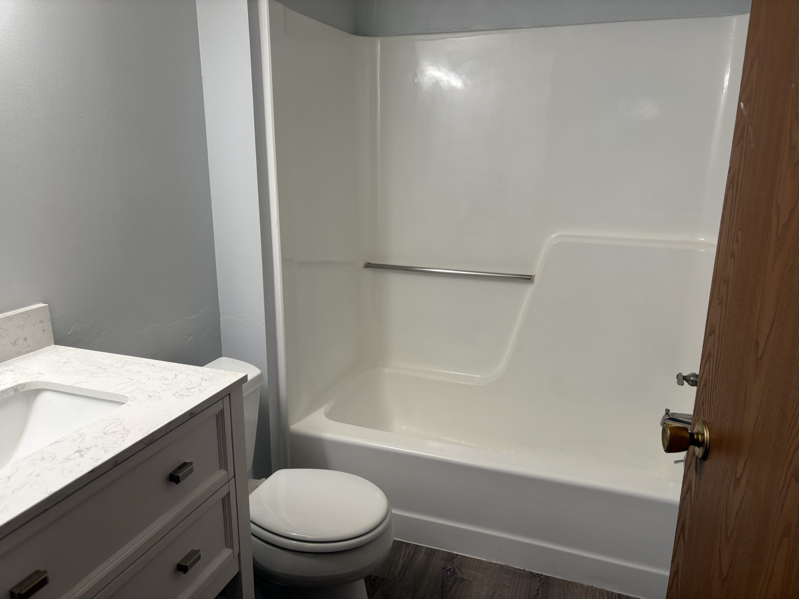 Bathroom with white tub, toilet, and vanity