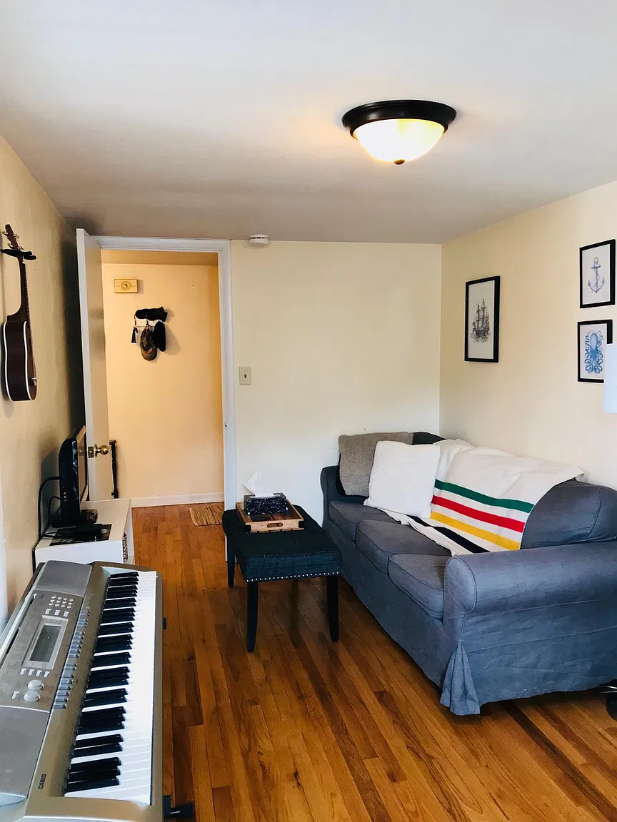 Living room with sofa, piano, and guitar