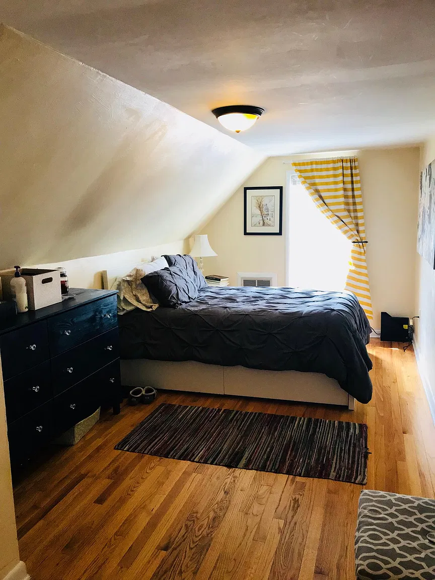Attic bedroom with slanted ceiling and dresser