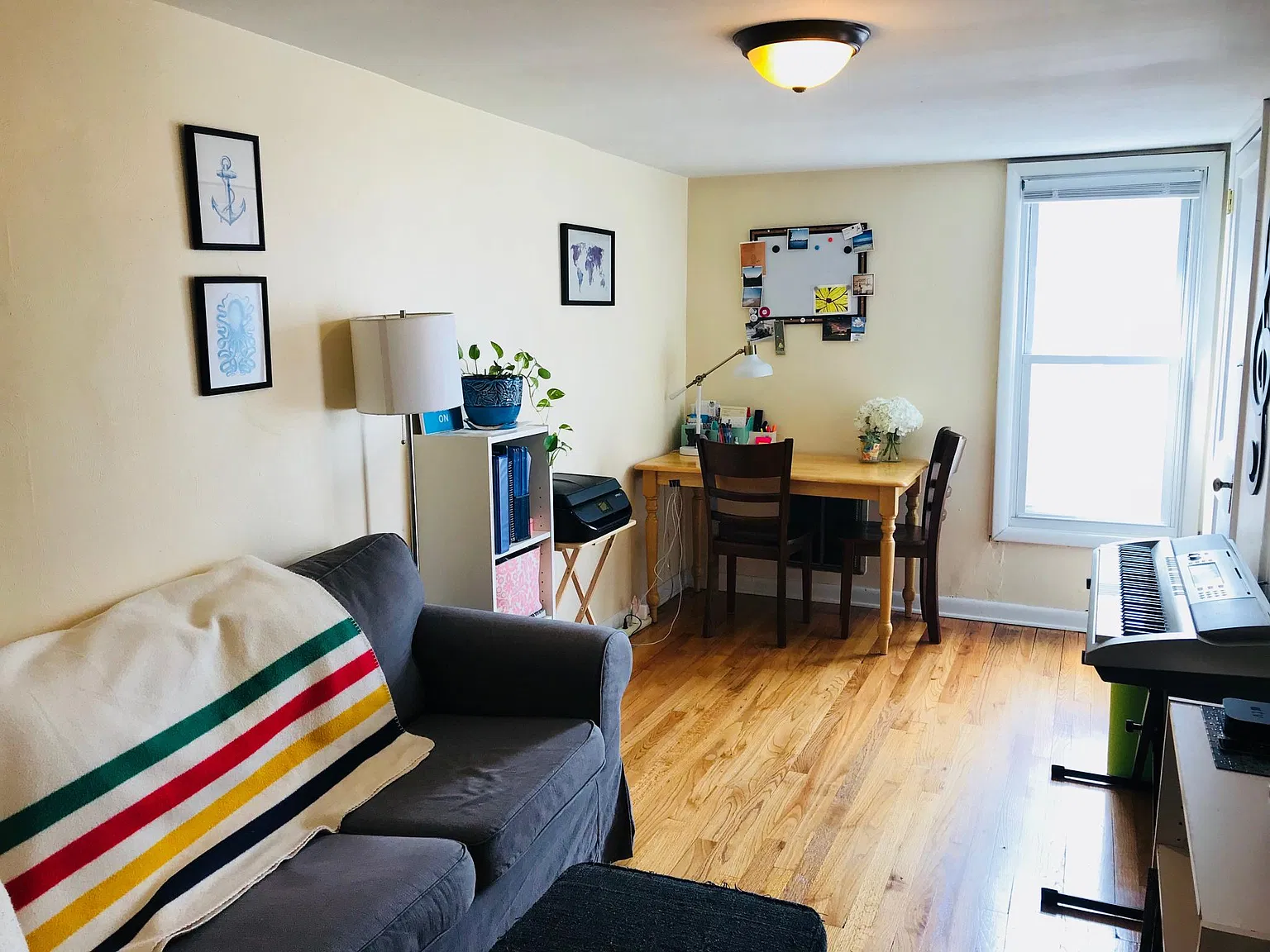 Living room with sofa, desk, and piano